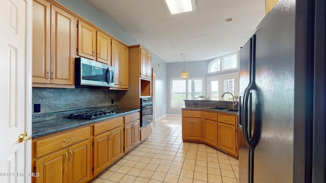 kitchen with tasteful backsplash, black appliances, dark countertops, and a sink