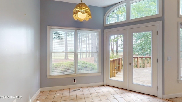 doorway with baseboards, visible vents, light tile patterned floors, and french doors