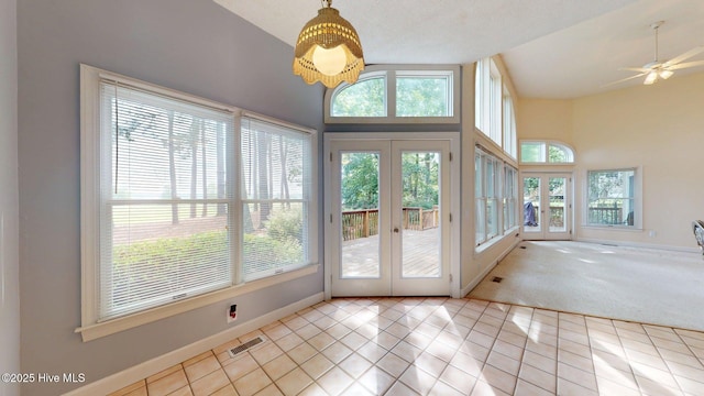 doorway with tile patterned floors, ceiling fan, baseboards, visible vents, and french doors