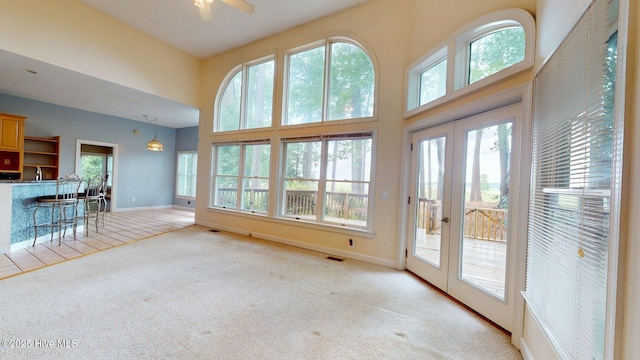 unfurnished living room featuring light colored carpet, french doors, visible vents, and baseboards