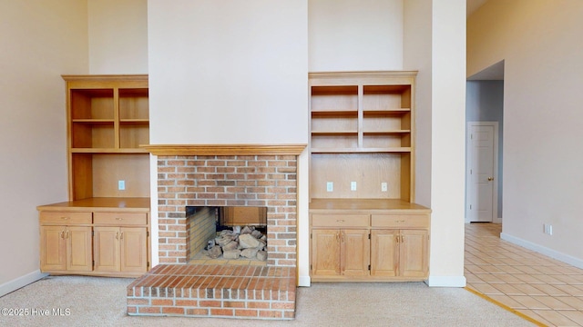 unfurnished living room with baseboards, light tile patterned floors, and a fireplace