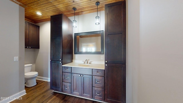 bathroom with wooden ceiling, vanity, toilet, baseboards, and wood finished floors