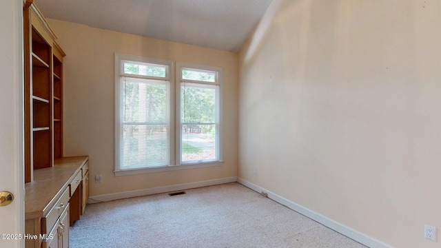 interior space with visible vents, light carpet, and baseboards