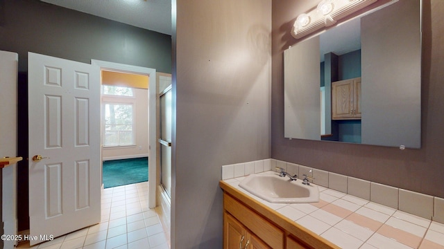 bathroom with tile patterned floors, a shower with door, and vanity