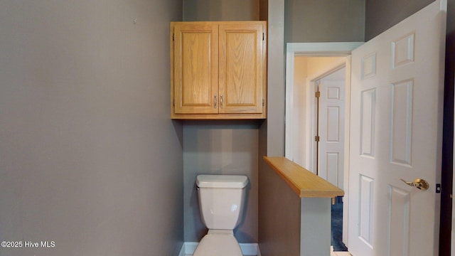 bathroom with baseboards and toilet