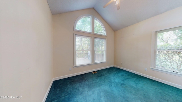 spare room with vaulted ceiling, a ceiling fan, and plenty of natural light