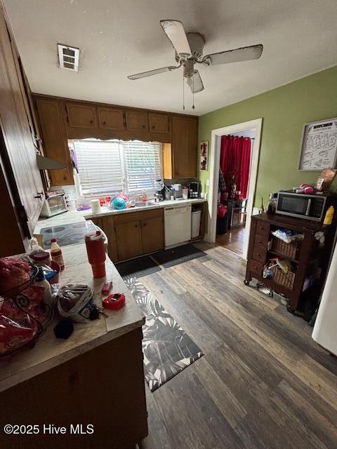 kitchen featuring visible vents, stainless steel microwave, white dishwasher, light countertops, and light wood-style floors