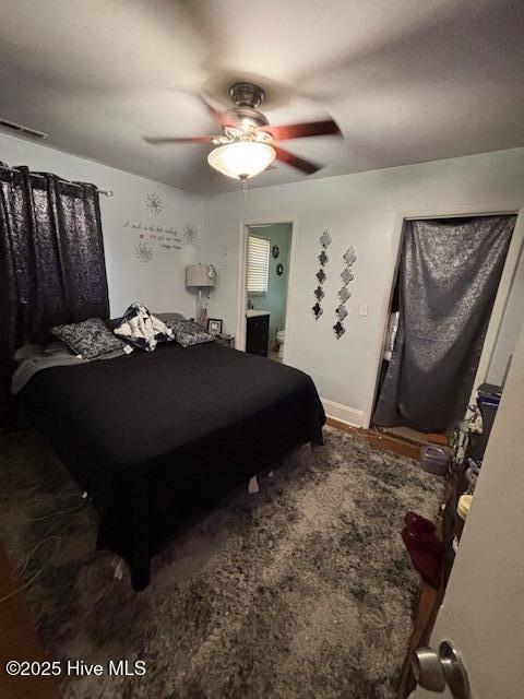 bedroom with ensuite bath and ceiling fan