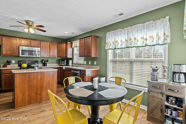 kitchen featuring light wood finished floors, visible vents, appliances with stainless steel finishes, and light countertops