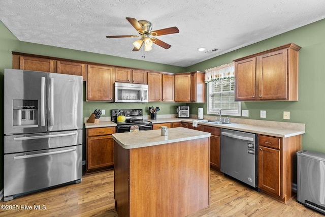 kitchen featuring visible vents, appliances with stainless steel finishes, light countertops, light wood-style floors, and a sink