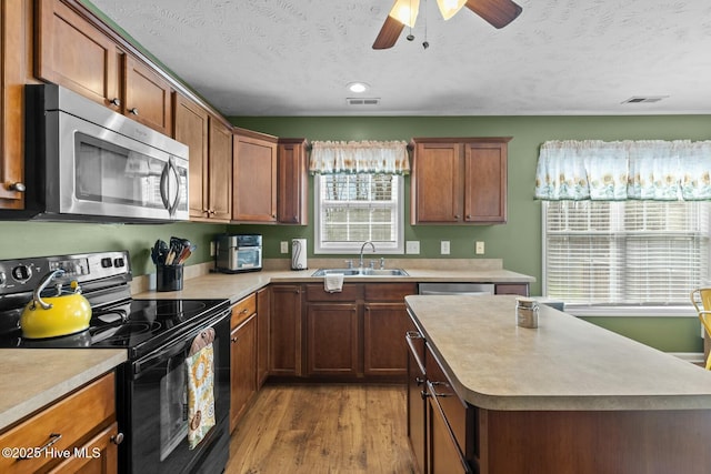 kitchen featuring stainless steel appliances, light countertops, a sink, and visible vents