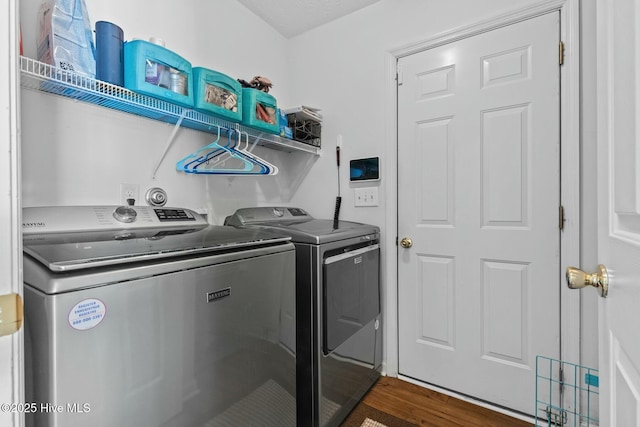 washroom featuring laundry area, washer and clothes dryer, and wood finished floors