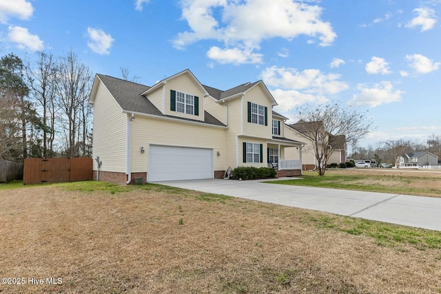 traditional-style home with concrete driveway, a front yard, and a gate