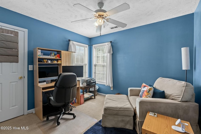 office space featuring carpet, visible vents, ceiling fan, and baseboards