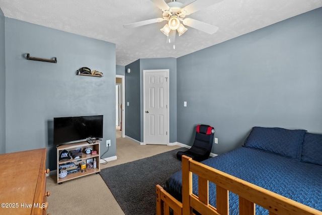 carpeted bedroom featuring a textured ceiling, ceiling fan, and baseboards