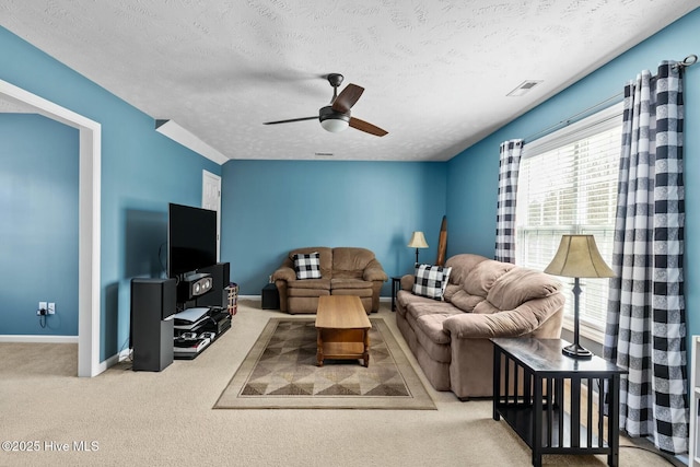 carpeted living area with baseboards, visible vents, ceiling fan, and a textured ceiling