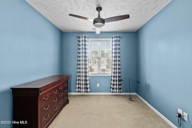 unfurnished room featuring light carpet, ceiling fan, a textured ceiling, and baseboards