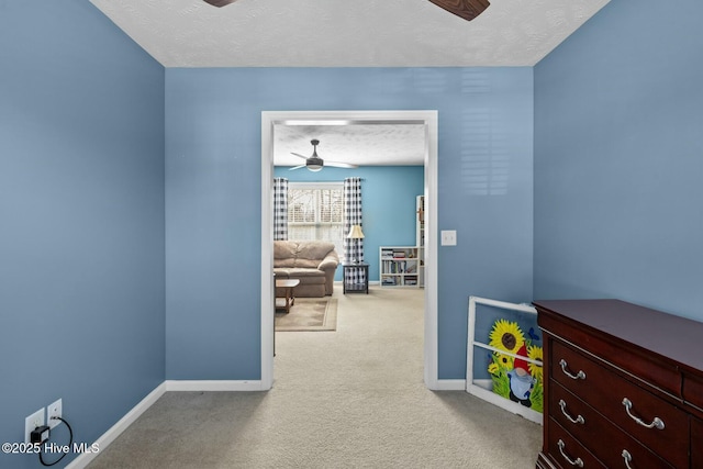 interior space featuring carpet floors, a textured ceiling, and baseboards