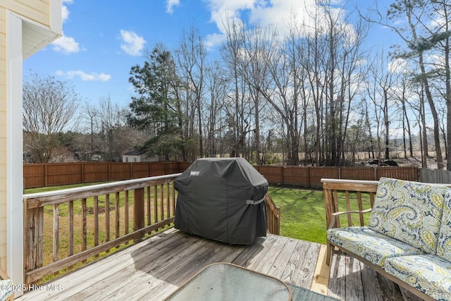 deck with a fenced backyard, a yard, and grilling area