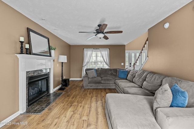 living room featuring baseboards, a fireplace, and light wood finished floors