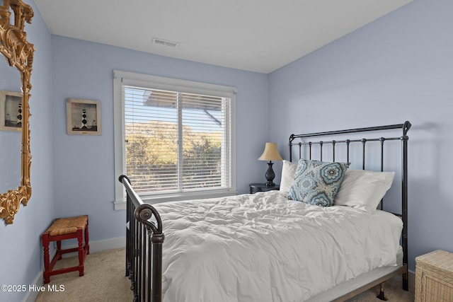 bedroom featuring baseboards, visible vents, and light colored carpet