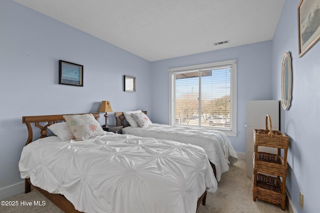 bedroom with visible vents, light carpet, and baseboards