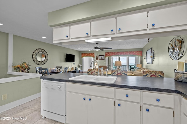 kitchen featuring dark countertops, white cabinets, dishwasher, and open floor plan