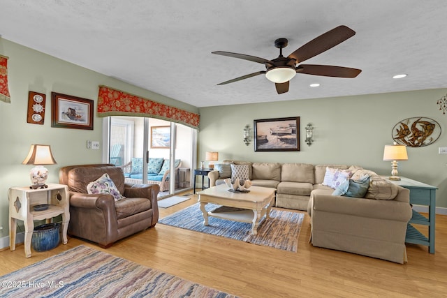 living area with a textured ceiling, ceiling fan, light wood-style flooring, recessed lighting, and baseboards