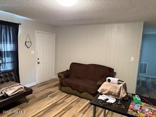 living area with a textured ceiling and wood finished floors