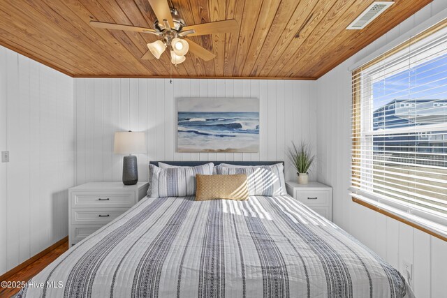 bedroom featuring visible vents, wood ceiling, a ceiling fan, light wood finished floors, and ensuite bath