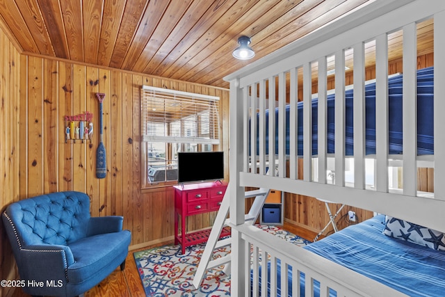 bedroom featuring wooden ceiling, wood finished floors, and wooden walls