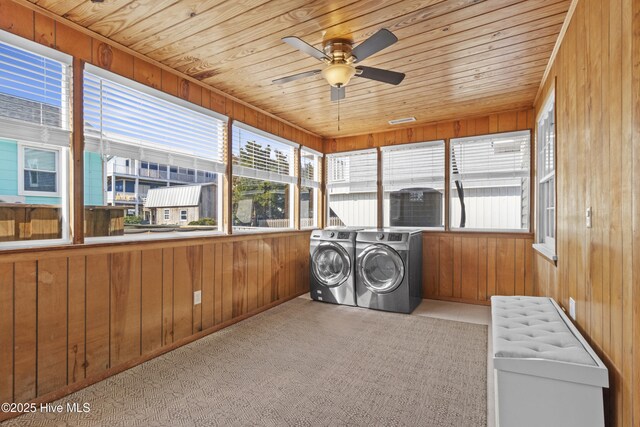 clothes washing area with ceiling fan, wooden walls, wood ceiling, and washer and dryer