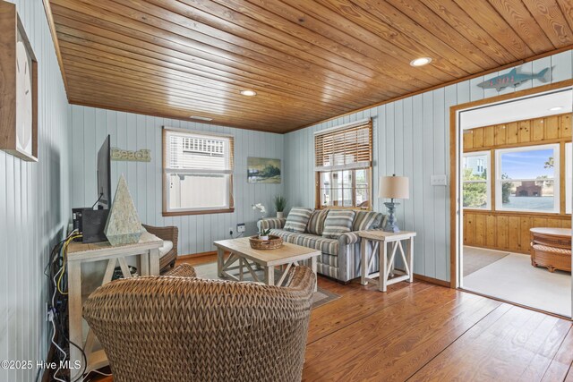 living area featuring wooden ceiling, hardwood / wood-style flooring, and baseboards