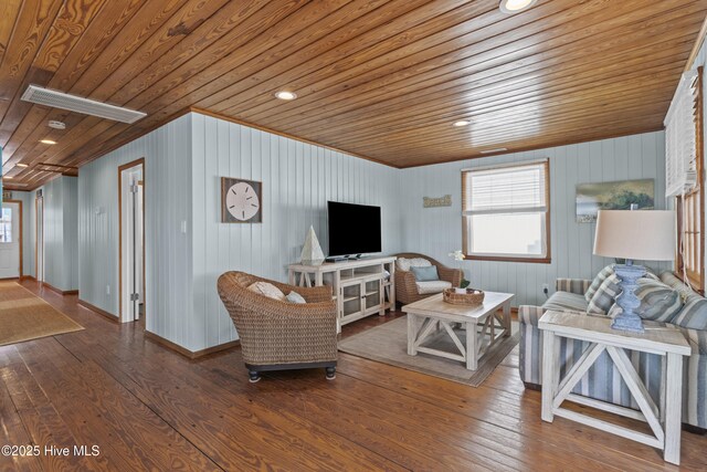 interior space with a ceiling fan, carpet, visible vents, and wood walls