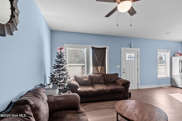 living room featuring baseboards, wood finished floors, and a ceiling fan