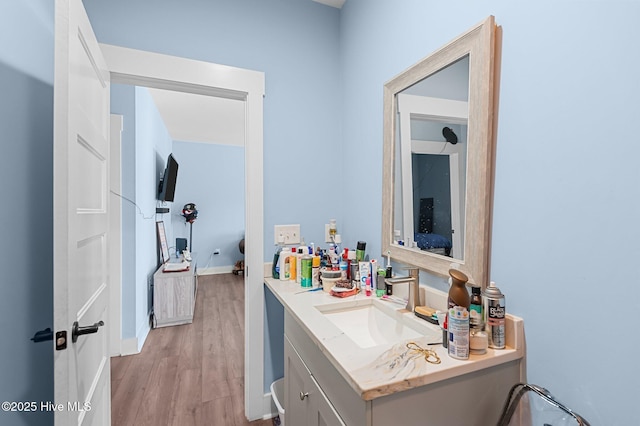 bathroom with vanity, baseboards, and wood finished floors