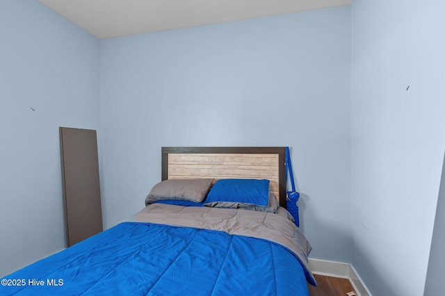 bedroom featuring wood finished floors and baseboards