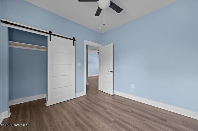 105 Bryan Pl, Washington, NC 27889 - unfurnished bedroom featuring a barn door, wood finished floors, and baseboards