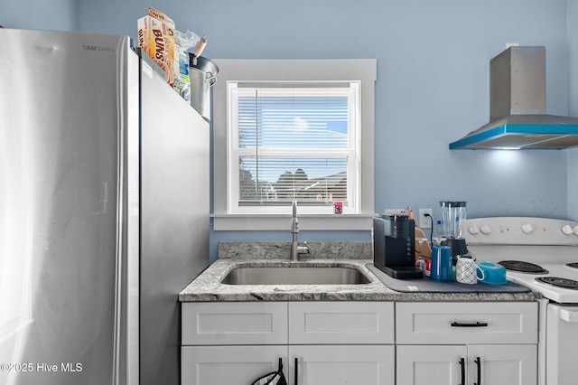 kitchen with white range with electric cooktop, island exhaust hood, a sink, white cabinetry, and freestanding refrigerator