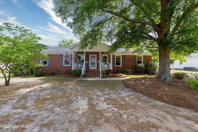 view of front of home with a porch, crawl space, and brick siding