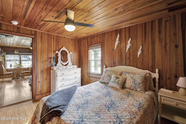 bedroom featuring light wood-style floors, wood ceiling, and wood walls