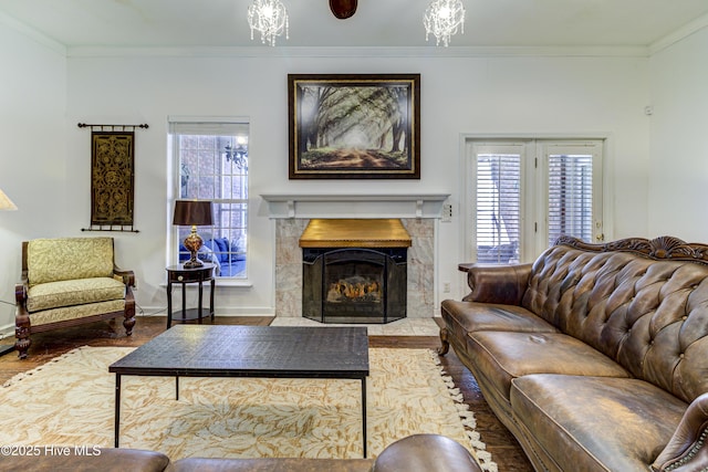 living area with plenty of natural light, a tiled fireplace, and crown molding