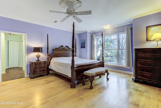 bedroom with light wood finished floors, baseboards, visible vents, a ceiling fan, and ornamental molding