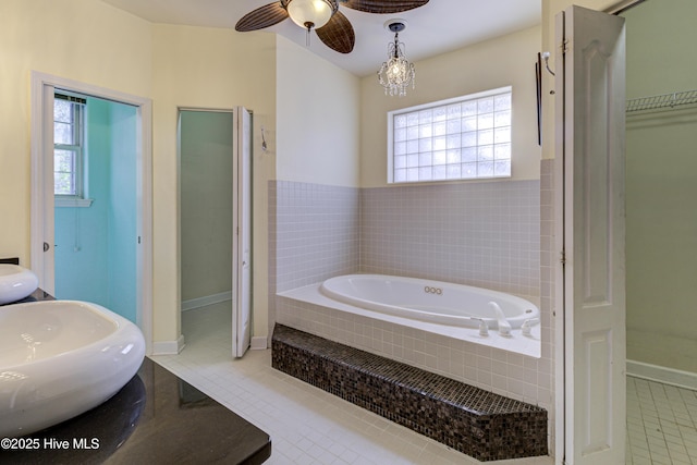 bathroom featuring a healthy amount of sunlight, a garden tub, tile patterned flooring, and a spacious closet