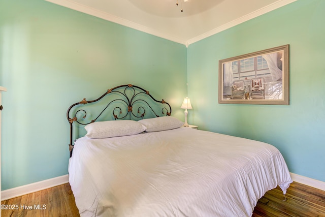 bedroom featuring ornamental molding, dark wood-style flooring, and baseboards