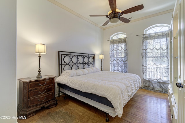 bedroom with visible vents, wood finished floors, a ceiling fan, and crown molding