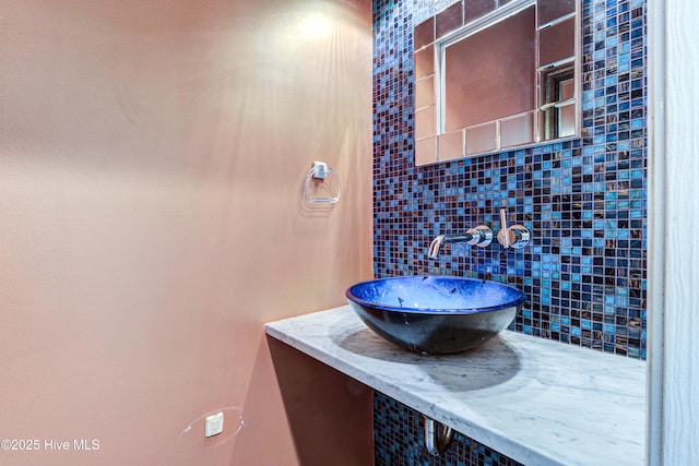 bathroom with a sink and backsplash