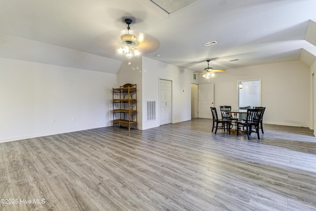 dining area with lofted ceiling, light wood-style floors, baseboards, and visible vents