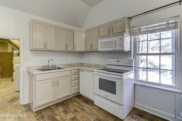 kitchen with lofted ceiling, white appliances, dark wood-style flooring, a sink, and light countertops