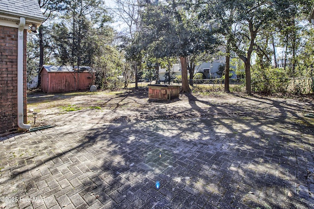 view of yard with a storage shed, a patio, an outdoor structure, and fence